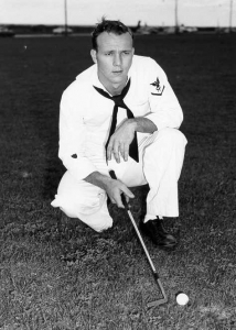A photograph of a young Arnold Palmer with club in hand. 